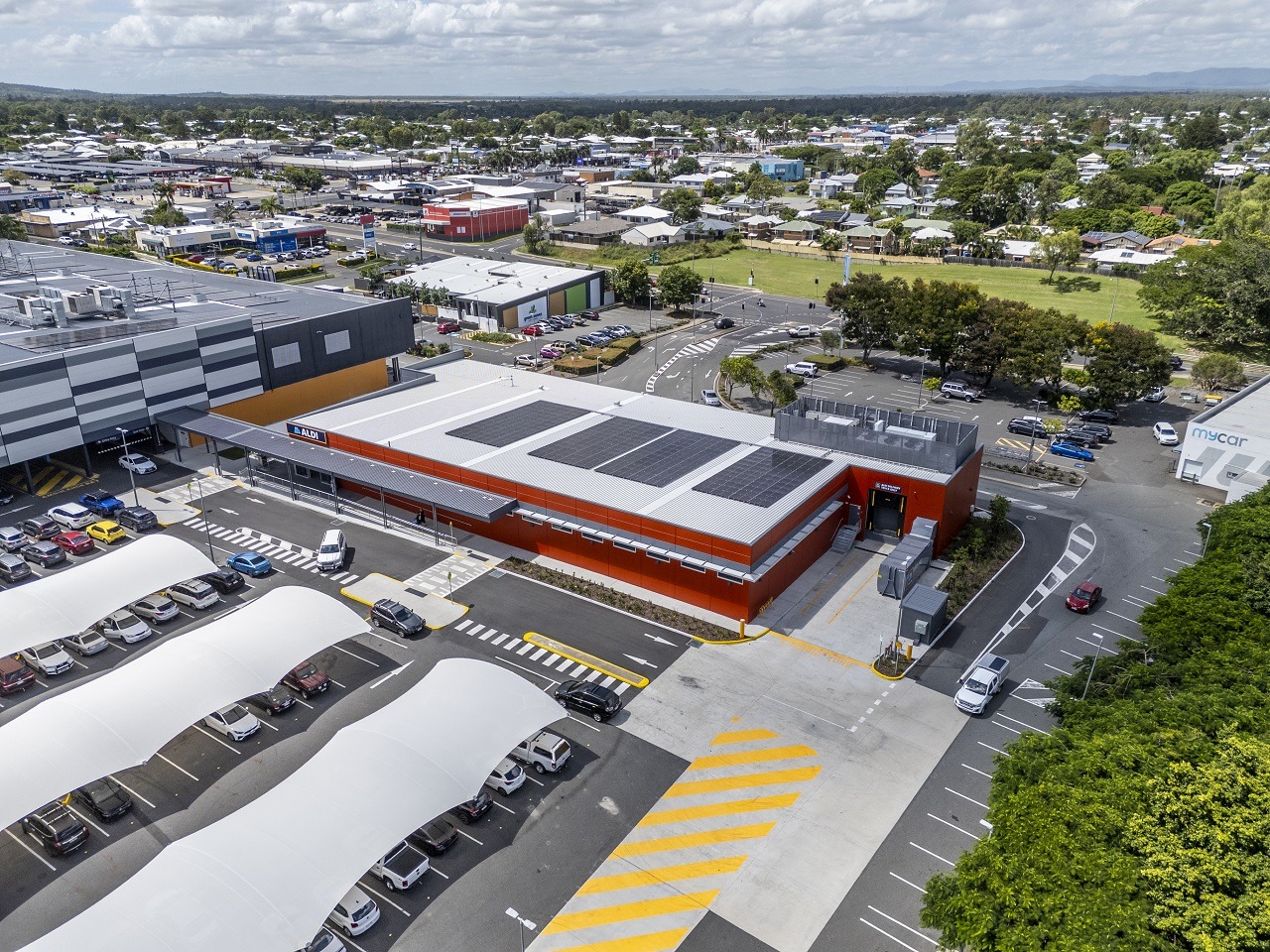 Aerial view of the ALDI Rockhampton store with rooftop solar, within a retail centre with shade-sail car parking