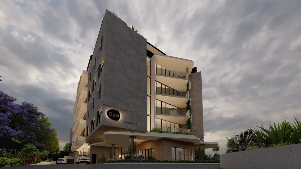 Street view of the Opal Carindale aged-care building, with stacked curved white balconies and stone-clad walls