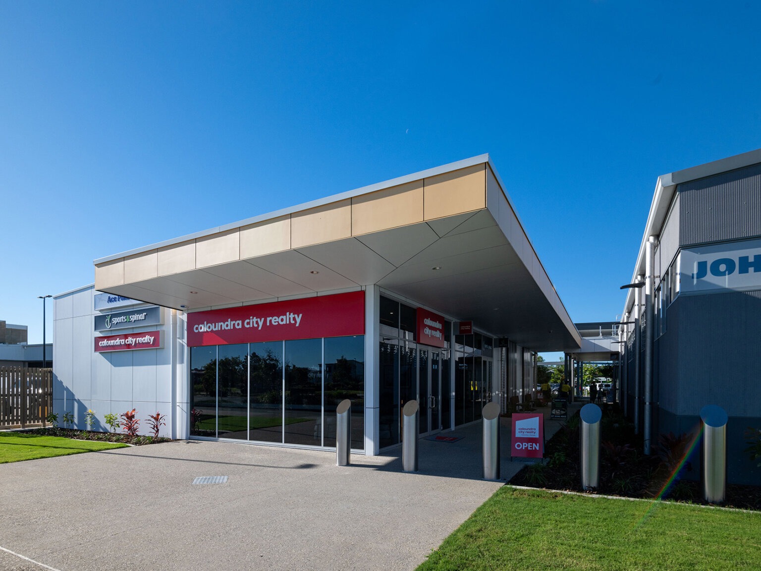 A retail tenancy at Stockland Baringa, with an angular cantilevered entry canopy over a glazed shopfront